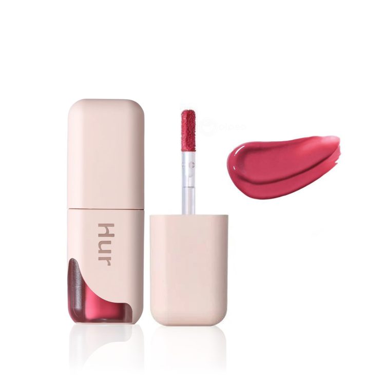 House of Hur Glowy Ampoule Tint нијанса #01 Deep Rose, течен кармин со апликатор во розово-беж пакување и прозорче што ја открива бојата, прикажан заедно со примерок од сјајната розова текстура. House of Hur Glowy Ampoule Tint in shade #01 Deep Rose, a liquid lip tint with applicator, shown in soft beige packaging with a window revealing the color, alongside a swatch of its glossy deep rose texture.