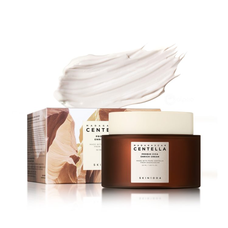 Пакување и тегличка од SKIN1004 Madagascar Centella Probio-Cica Enrich Cream 50ml, прикажани со текстура од кремата во позадина. Packaging and jar of SKIN1004 Madagascar Centella Probio-Cica Enrich Cream 50ml, shown with cream texture in the background.