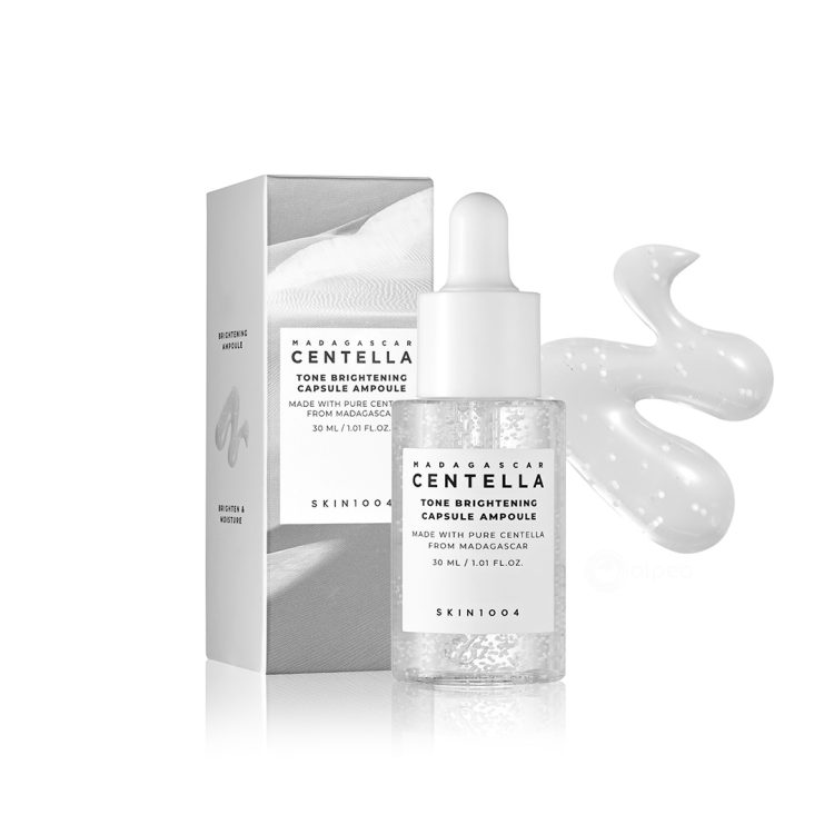 SKIN1004 Madagascar Centella Tone Brightening Capsule Ampoule 30ml – ампула за изедначување на тенот со микро-капсули, сместена во транспарентно шише со пипета и стилска сива амбалажа. SKIN1004 Madagascar Centella Tone Brightening Capsule Ampoule 30ml – tone-correcting ampoule with micro-capsules, in a transparent dropper bottle with sleek grey packaging.
