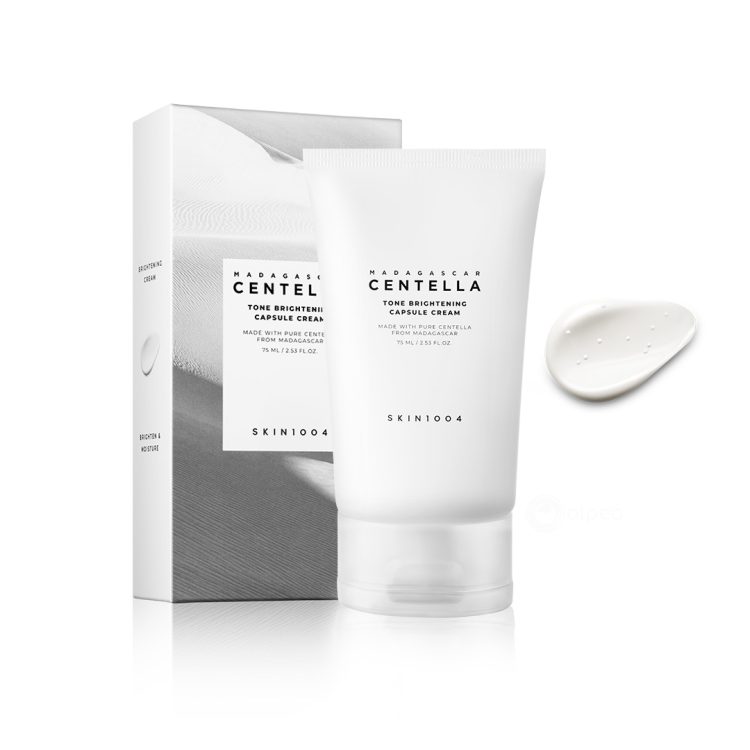 SKIN1004 Madagascar Centella Tone Brightening Capsule Cream 75ml – крем за осветлување на тенот со капсули Madewhite™, прикажан со оригиналната амбалажа и текстурата на кремот. SKIN1004 Madagascar Centella Tone Brightening Capsule Cream 75ml – brightening tone cream with Madewhite™ capsules, shown with original packaging and cream texture.