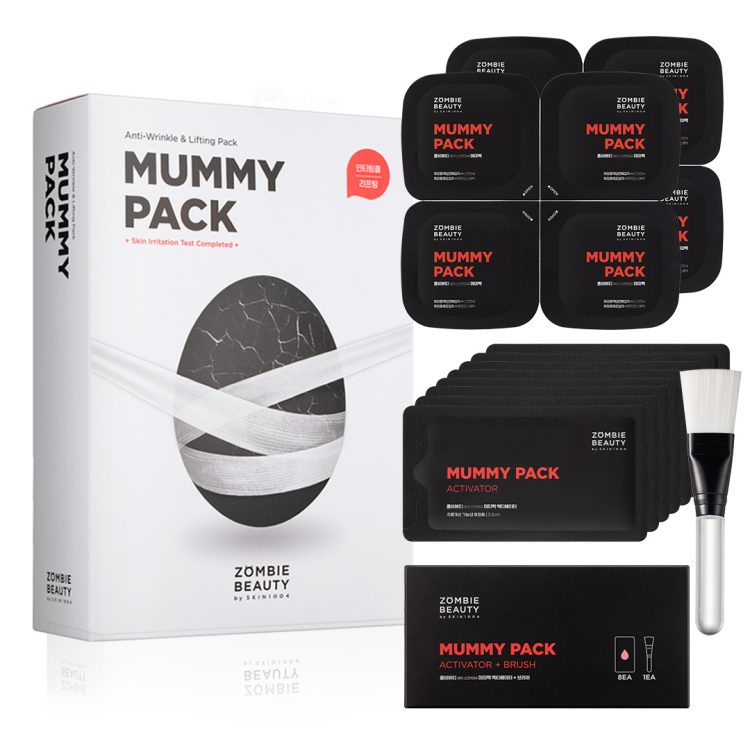 Пакување од Zombie Beauty Mummy Pack од SKIN1004, прикажува сет со 8 маски во црни пакувања, 8 саше-активатори, четка за нанесување и голема бела кутија со дизајн на замотано јајце, наменето за лифтинг и антиејџ ефект. Zombie Beauty Mummy Pack by SKIN1004, featuring a set of 8 black mask containers, 8 activator sachets, an application brush, and a large white box with a wrapped-egg design, intended for anti-wrinkle and lifting skincare treatment.